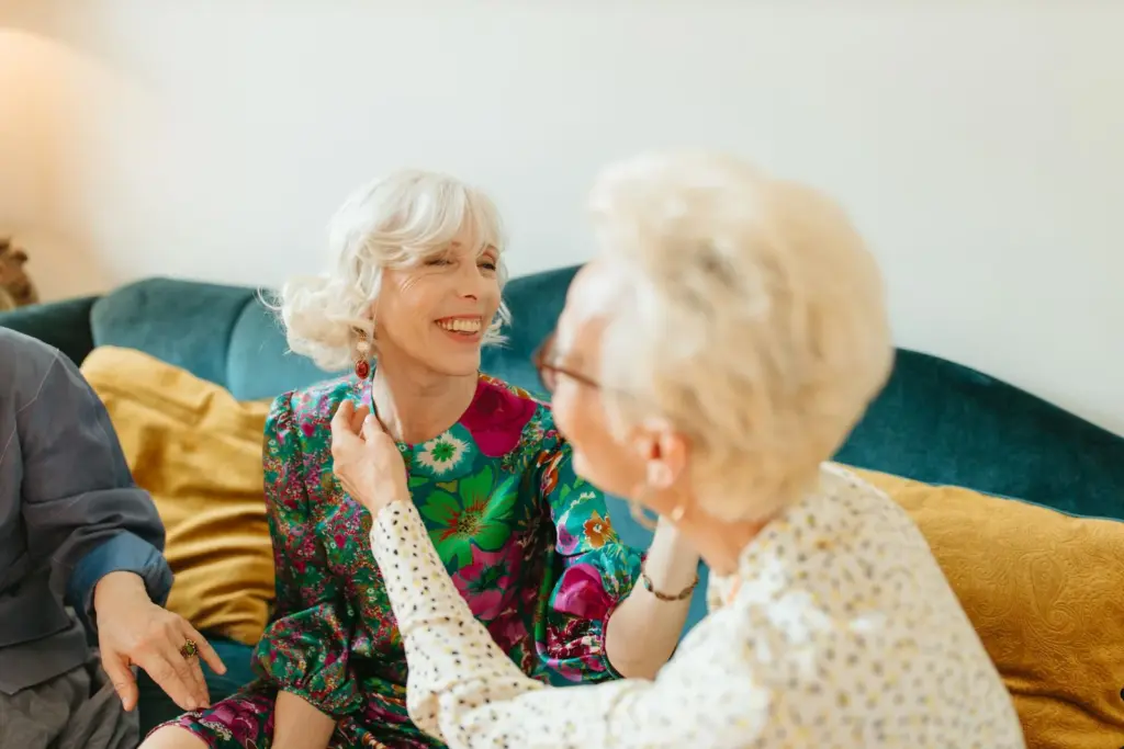 Zwei Frauen lachen gemeinsam auf dem Sofa
